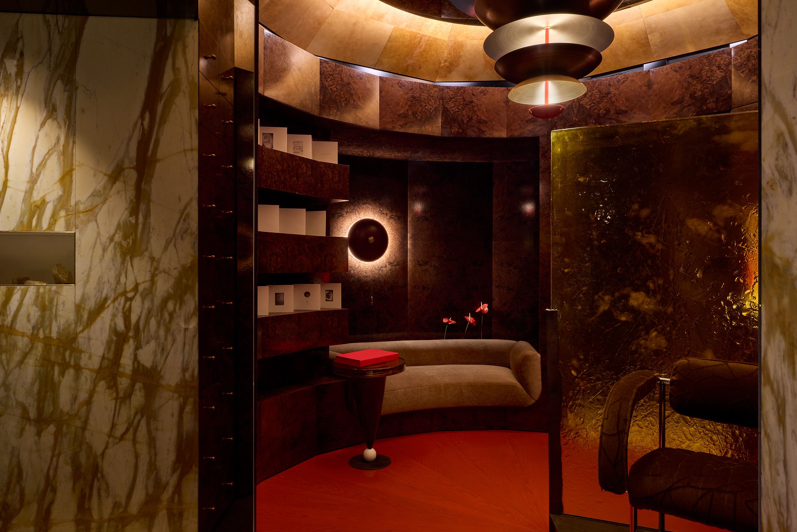 a small room with red floors, burl wood walls, marble and atmospheric lights