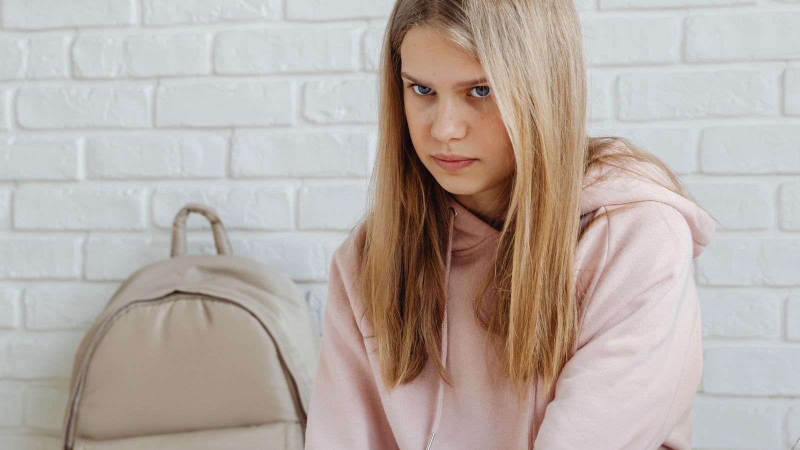 sad teen girl in pink hoodie