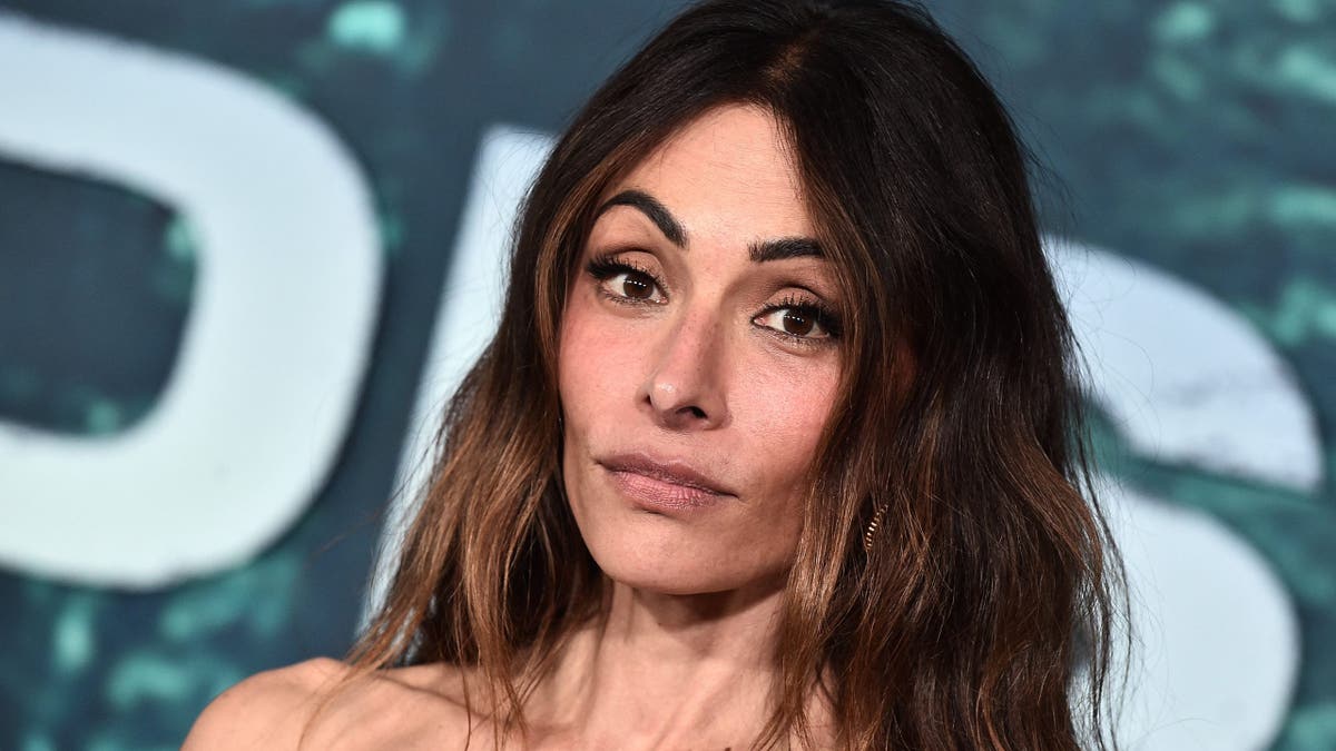 Sarah Shahi standing at the premiere of Paradise Season 2 at the Paramount Theatre in Los Angeles