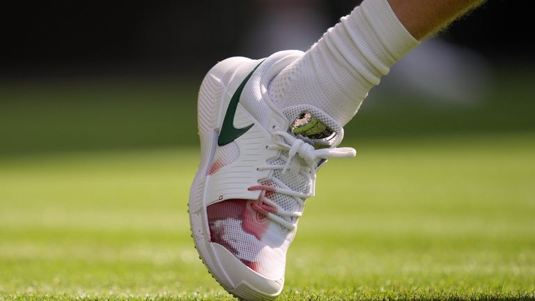 Italy's Jannik Sinner's right shoe shows a red stain during the men's singles match against Miomir Kecmanovic of Serbia at the Wimbledon Ten