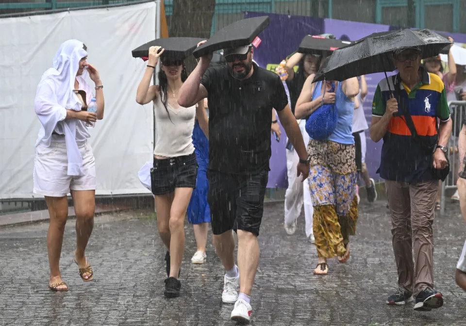Fans shelter from rain at the Berlin Open.