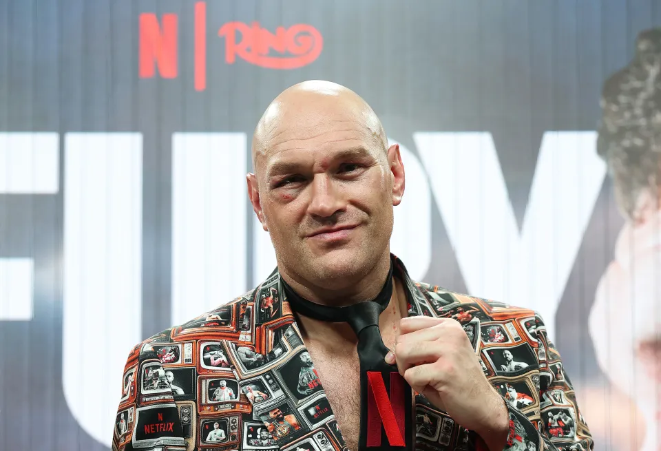 Tyson Fury points to the Netflix logo on his tie as he speaks to the media during a press conference after his victory in the Heavyweight fight between Tyson Fury and Arslanbek Makhmudov