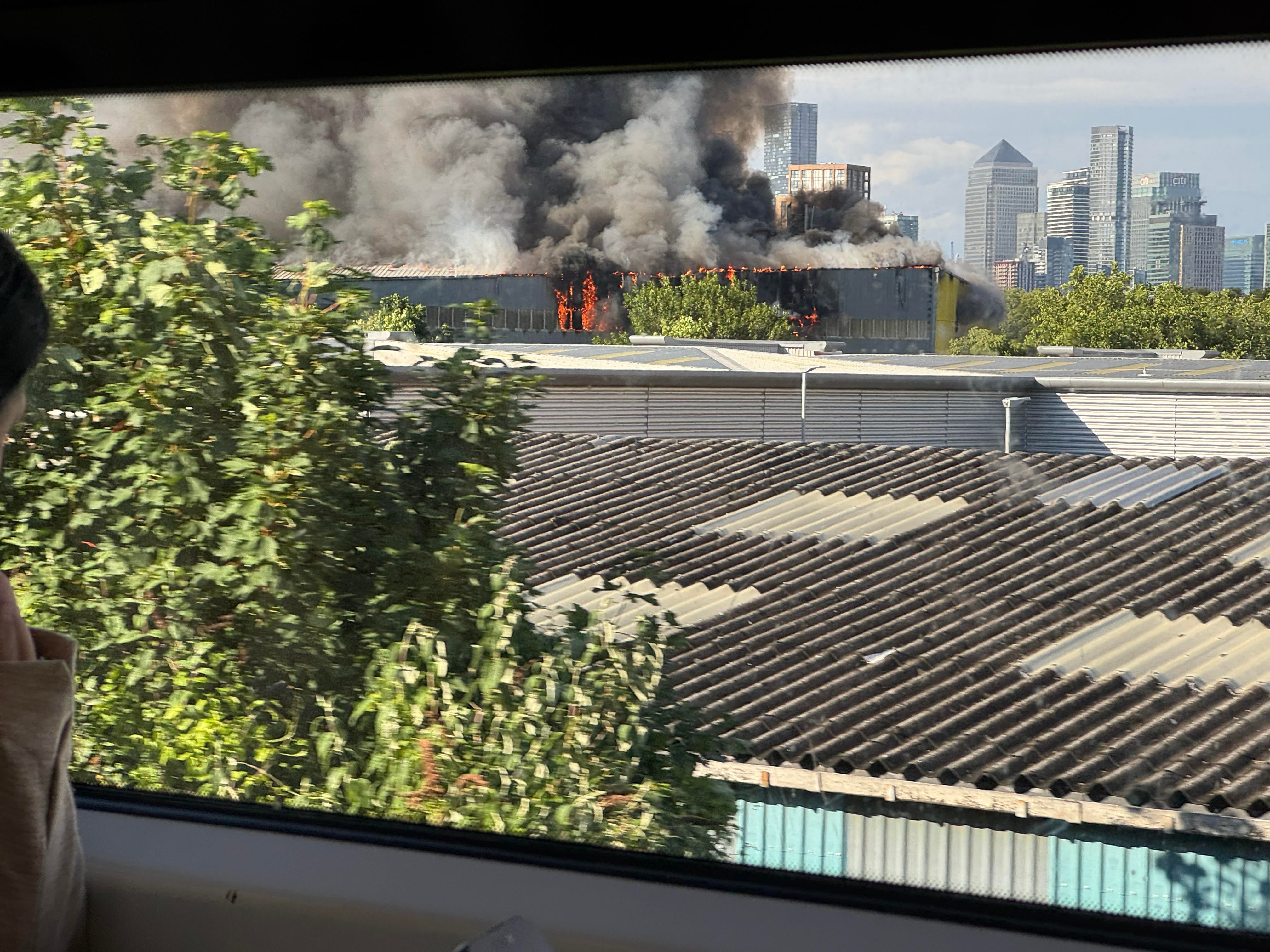 Smoke and flames from the site of a major fire in London, as seen from a train from London Bridge