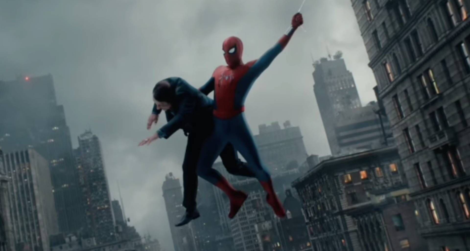 A screenshot from a Spider-Man: Brand New Day trailer clip featuring Spider-Man web-swinging while holding a man