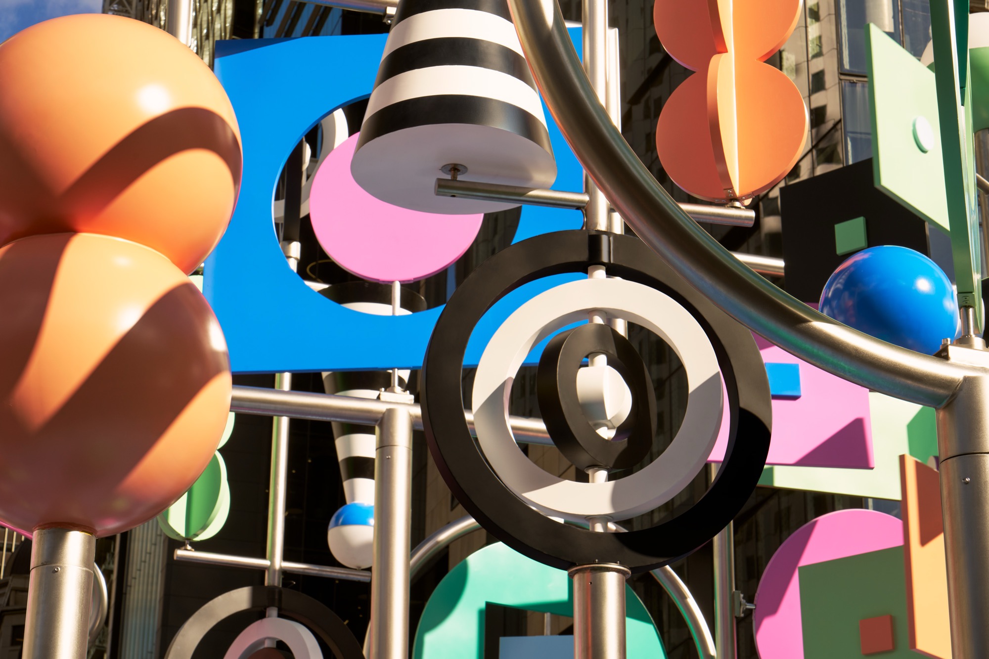 a detail photo of a colorful outdoor sculpture with twirling shapes by Wade and Leta