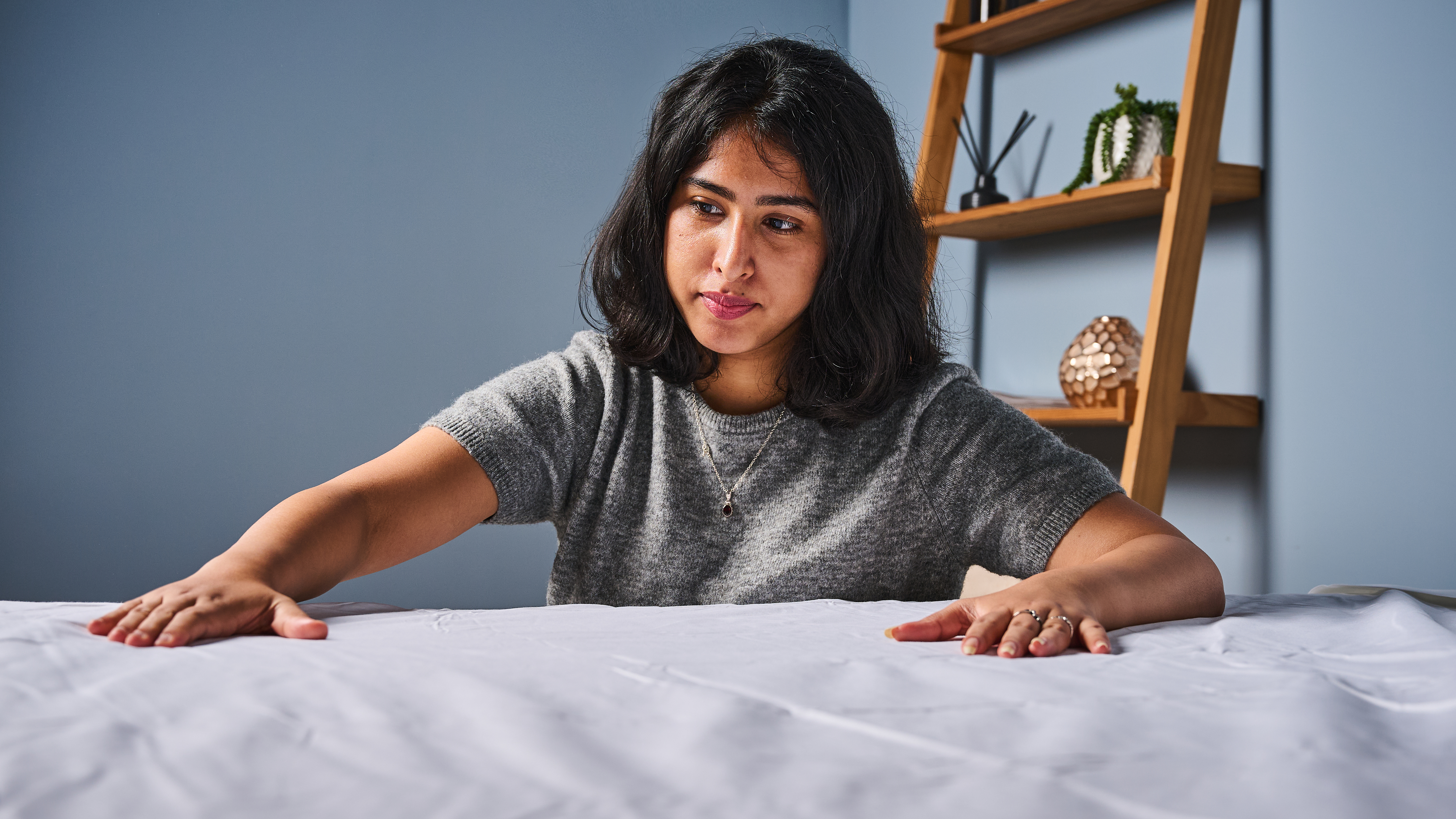 TG bedding writer placing hands on the Coop Percale sheet set