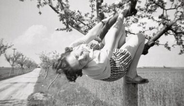a black-and-white snapshot of a woman in a tree