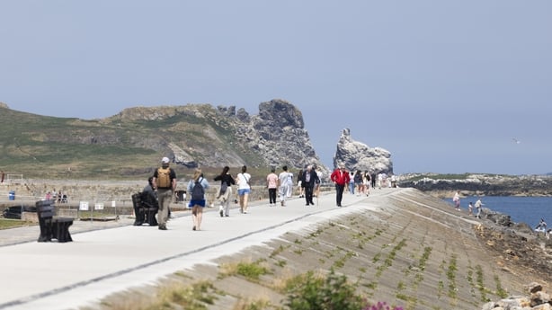 People enjoying a stroll during the sunny weather on Howth Pier in Dublin