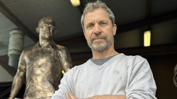 Artist Mark Rode with a statue of Mick Murphy