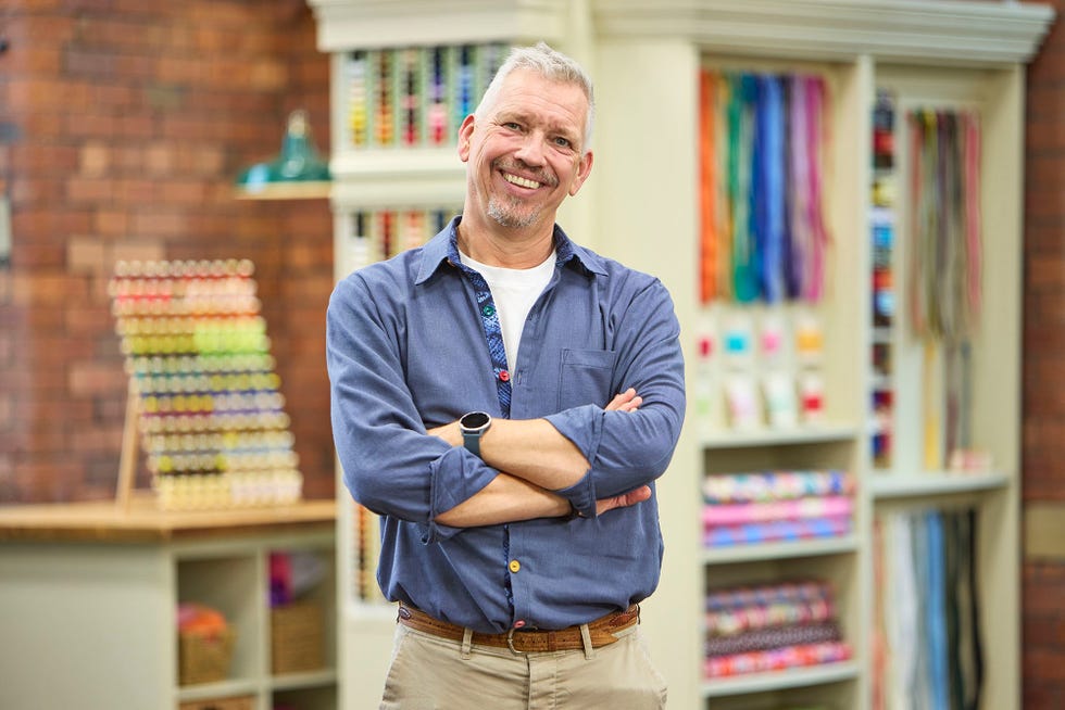 Tim contestant in the Great British Sewing Bee S12 2026 tim contestant in the great british sewing bee s12 2026 standing in studio smiling at camera