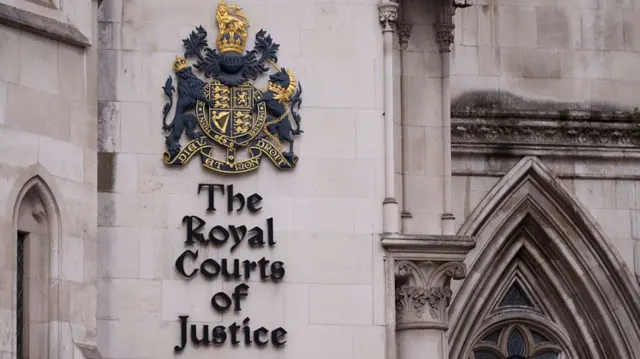 The sign for the Royal Courts of Justice, set on the stone wall of the building