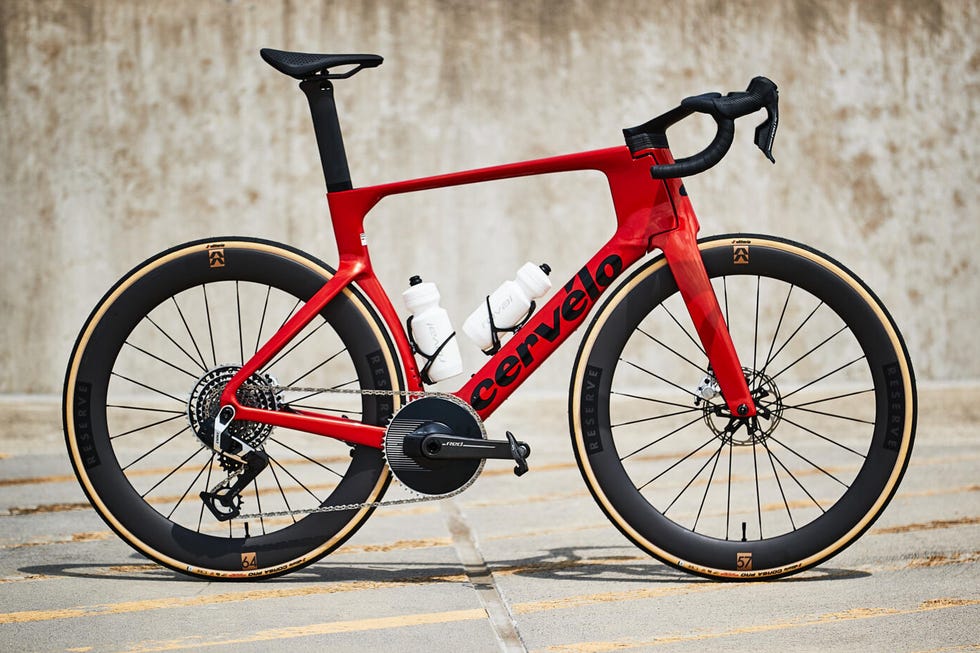 A sleek red Cervélo road bike with aerodynamic design and two water bottles, set against a neutral background.
