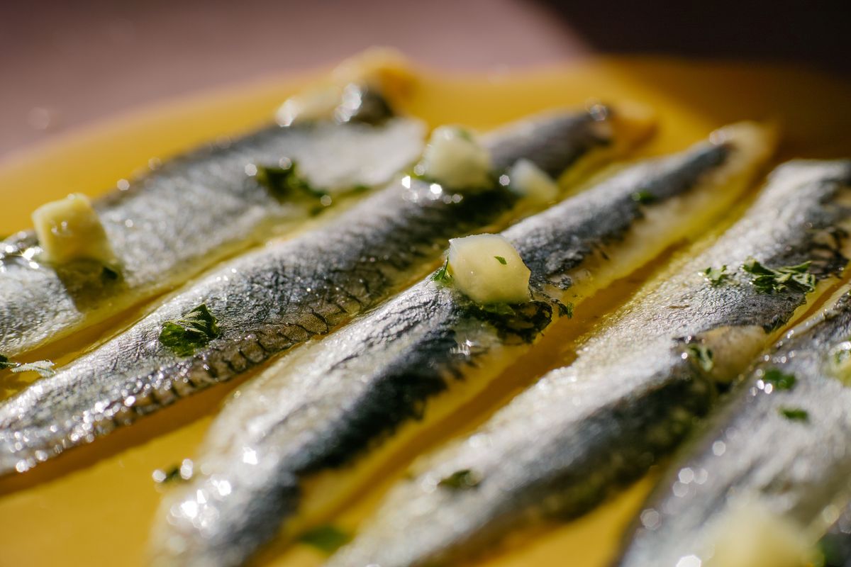 Close-up of an anchovy in vinegar with garlic, parsley and olive oil. Spanish food