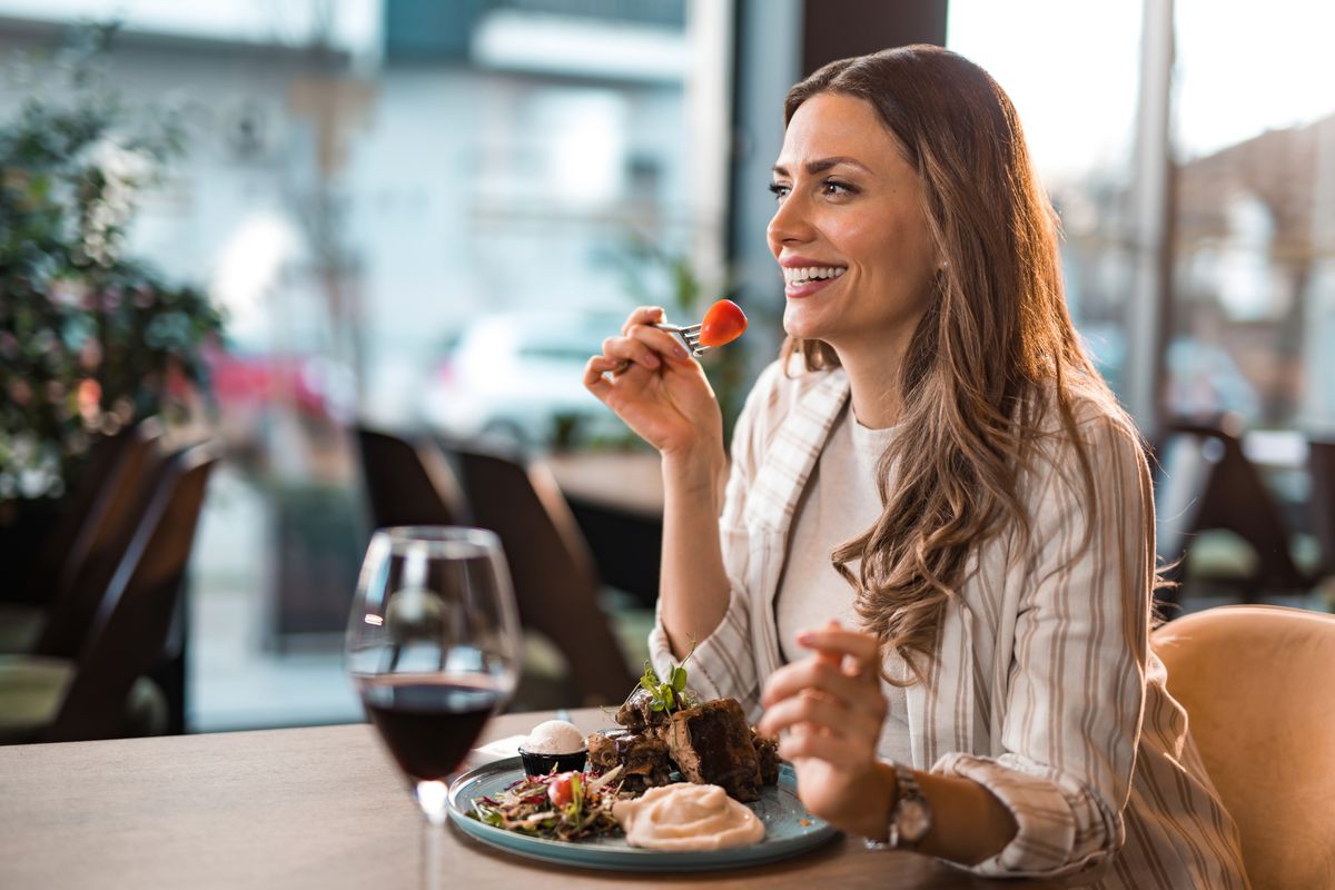 A woman having steak and wine