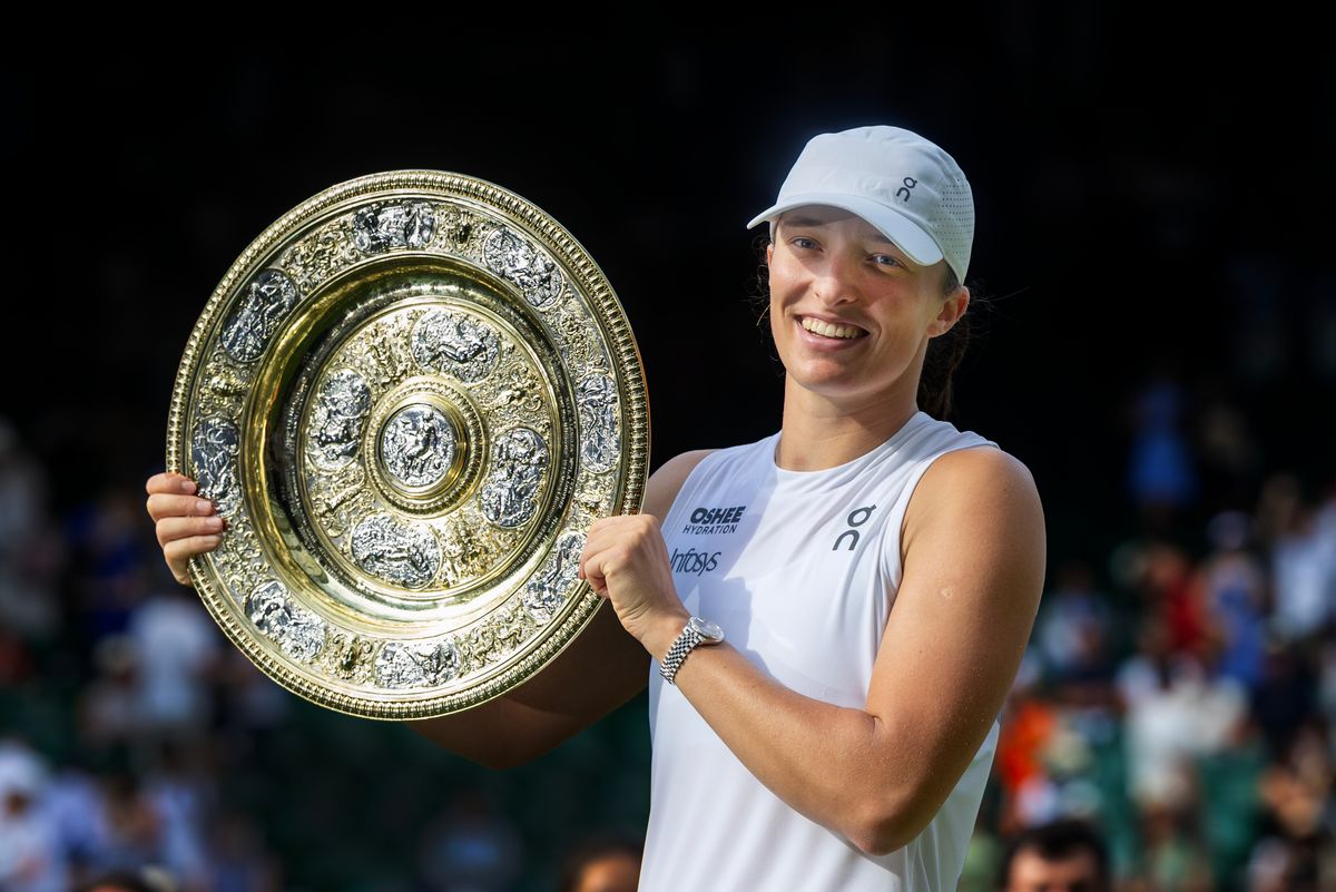 Iga Swiatek of Poland with the winners' trophy after her victory against Amanda Anisimova of the United States in the Women's Singles Final on Centre Court
