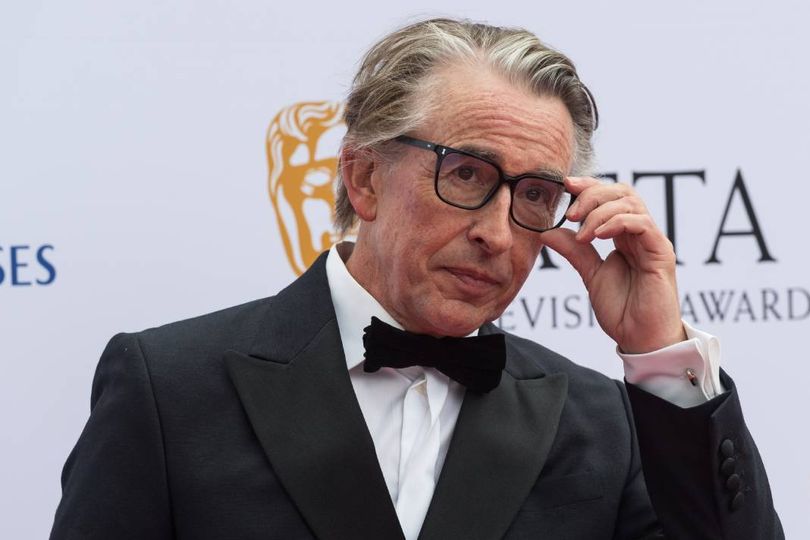 Grey haired man wearing suit and glasses