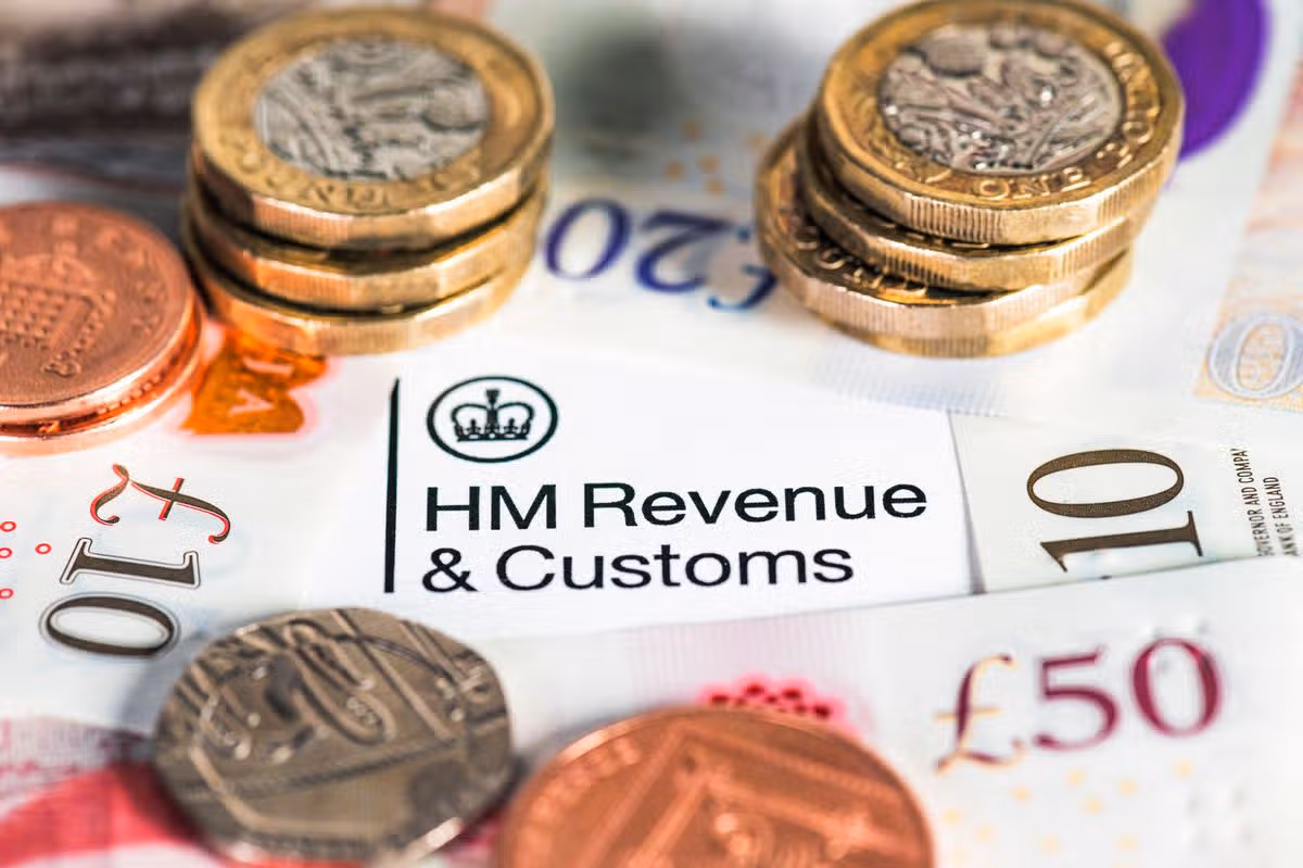 A collection of modern British banknotes surrounding the HM Revenue & Customs heading on a UK Government tax form.