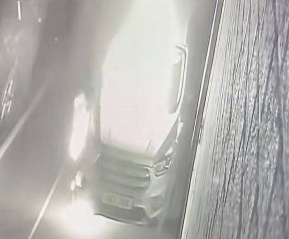 The image depicts an interior view of a vehicle, with a focus on the driver's side. A portion of the dashboard is visible, along with the steering wheel. The overall scene is bathed in a soft, diffused light, and the image appears to have a slight blur, possibly due to movement or a low-quality capture. The background includes a glimpse of the vehicle's door and a textured surface, likely the car's interior paneling.