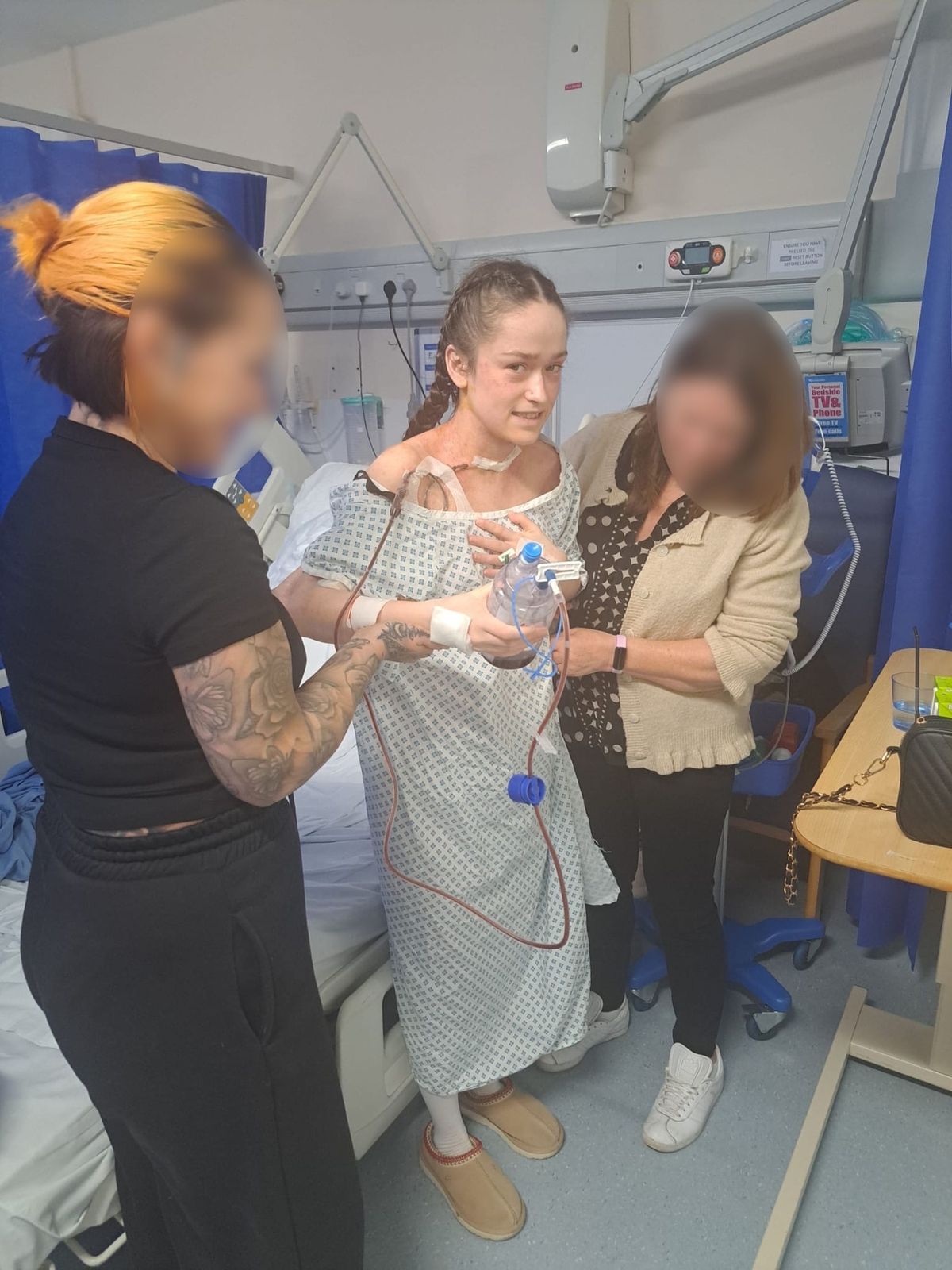 Emily being assisted to stand by hospital staff