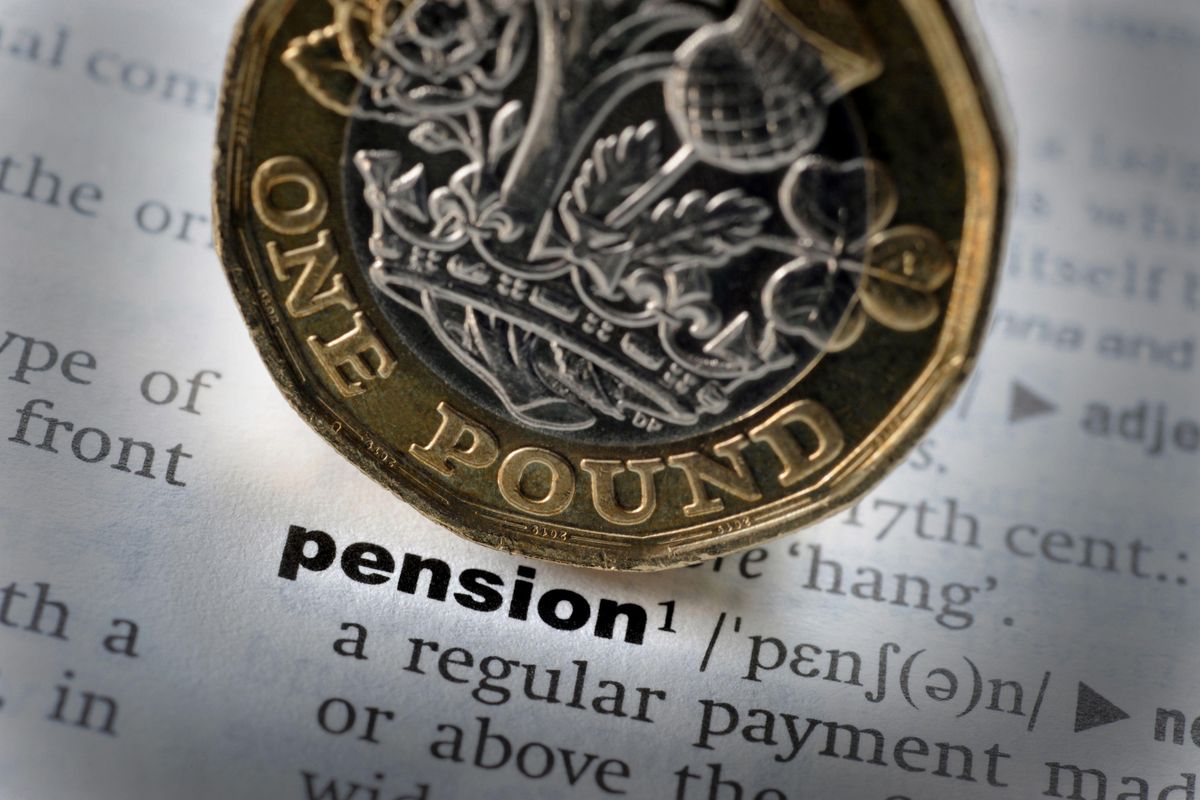 This is a generic photo of a British one pound coin next to the definition of pension in a dictionary