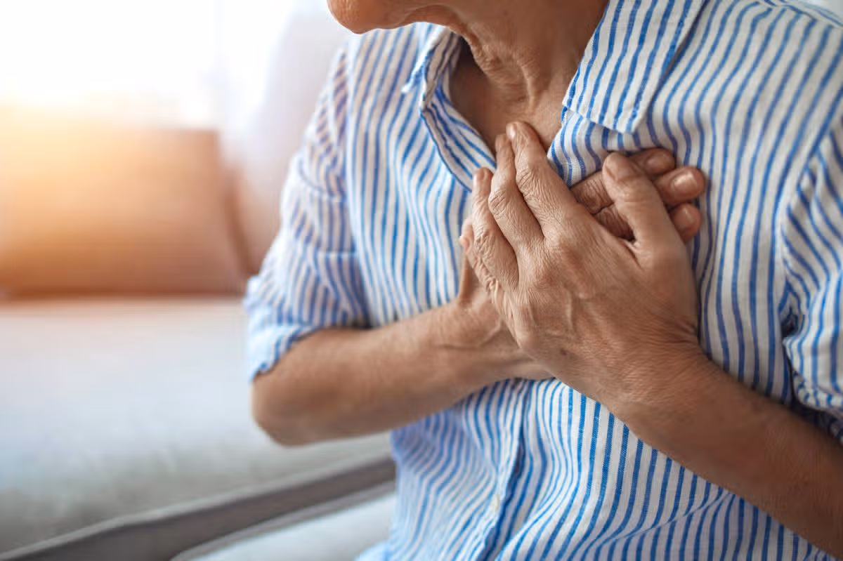 Upset stressed mature middle aged woman feeling pain ache touching chest having heart attack, sad worried senior older lady suffers from heartache at home, infarction or female heart disease concept