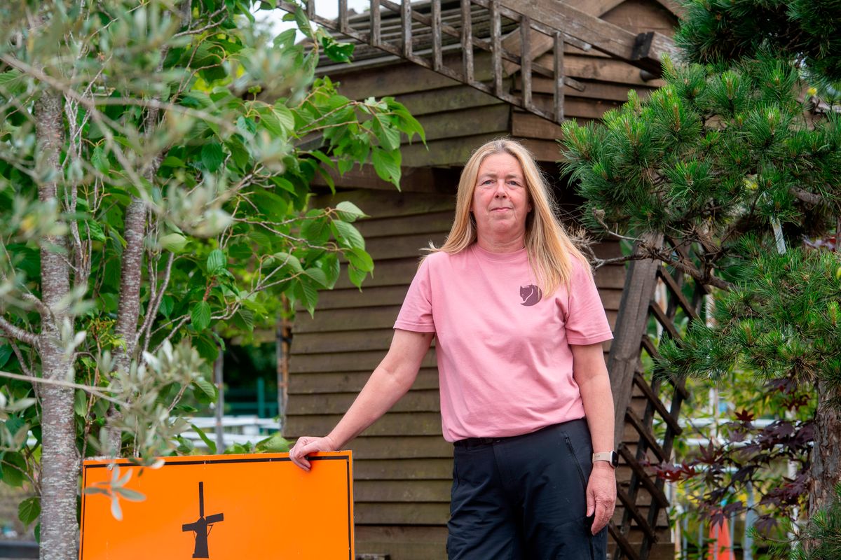  owner Lisa Jones standing in front of a large wooden windmill at the Dutch Garden centre, Cardiff, which is closing after 50 years. 