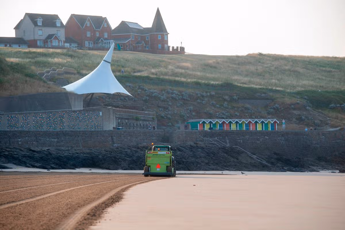 A tractor being driven on a beach