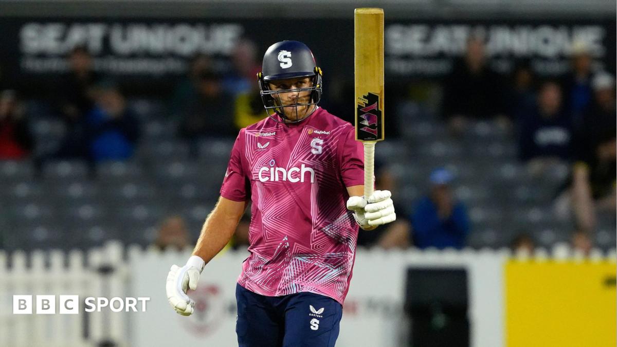 David Willey holding his bat aloft in his left hand after scoring a half-century for Northamptonshire Steelbacks