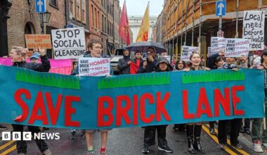 Campaigners march through Brick Lane carrying a large "Save Brick Lane" banner and placards opposing plans for data centres and calling for more homes.