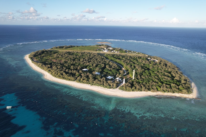 A drone image of a small island surrounded by coral reef