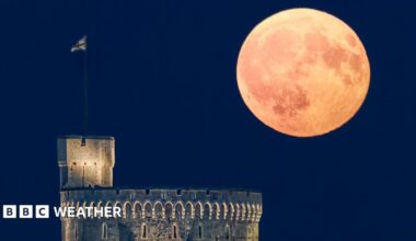 A large moon shining in a clear sky over Windsor Castle