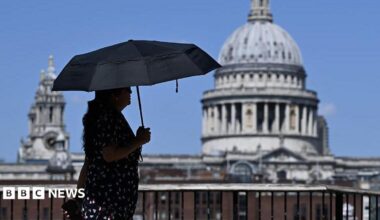 A woman walks under an umbrella past St Paul's Cathedral in London during the heatwave.
