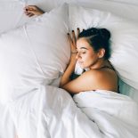 Sleep tourism in hotel. Exhausted woman sleeps sweetly in bed in the morning - stock photo
