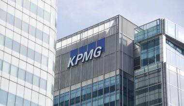 KPMG office building exterior with company logo under clear blue sky, representing global professional services firm