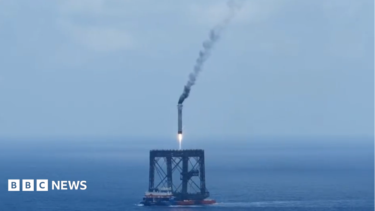 A screengrab of  a Long March 10B booster rocket landing on a recovery platform.