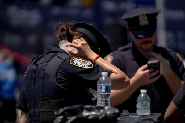 A police officer holds ice to their neck to try and stay cool following the 2026 Nathan's Famous Fourth of July hot dog eating contest at Coney Island in the Brooklyn borough of New York, July 4, 2026. (AP Photo/Anna Connors, File)