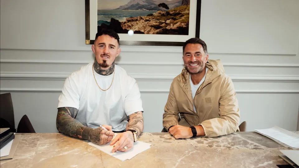 Tom Aspinall signing his contract sat next to Eddie Hearn