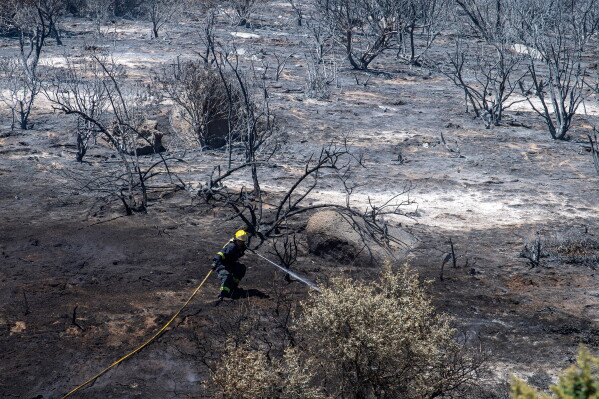A firefighter battles a wildfire on the slopes above Simon's Town, South Africa, Dec. 19, 2023. (AP Photo, File)