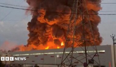 A fire ball rises above a low, light-coloured building.