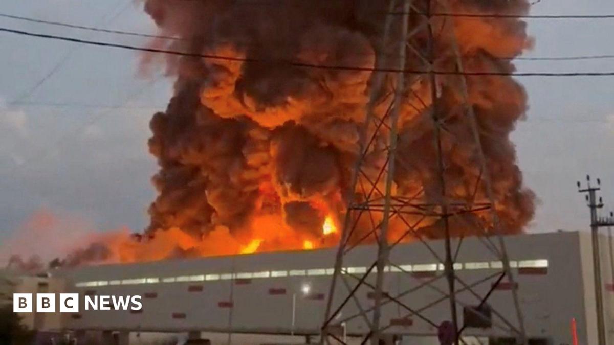 A fire ball rises above a low, light-coloured building.