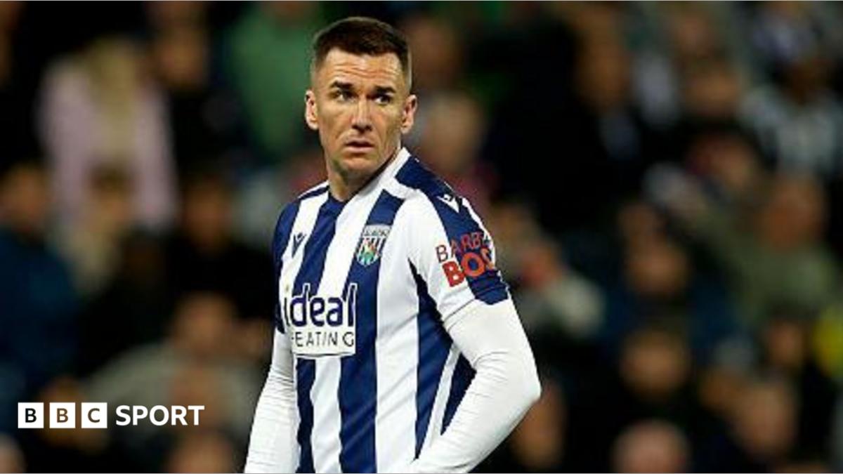 Jed Wallace in match action wearing a navy blue and white striped West Brom playing shirt with white shorts and the number seven in red on the left leg