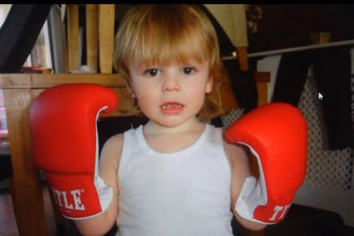 Logan Palmer as a three year old with his dad's boxing gloves