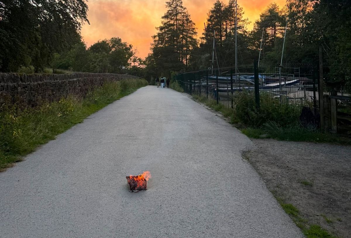 A smouldering remains of a box of fireworks left dumped on a footpath