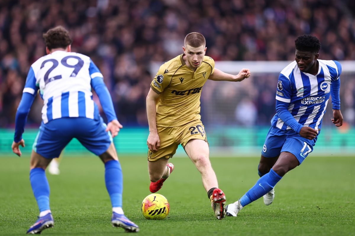 Adam Wharton of Crystal Palace takes on Maxim de Cuyper of Brighton & Hove Albion and Carlos Baleba of Brighton & Hove Albion during the Premier League match between Brighton & Hove Albion and Crystal Palace at Amex Stadium