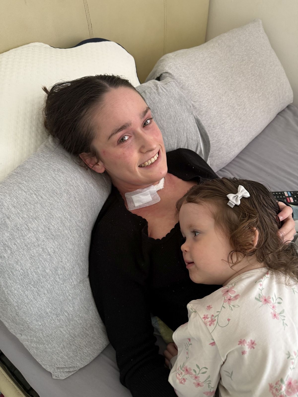 Harriet cuddling into her mum in hospital