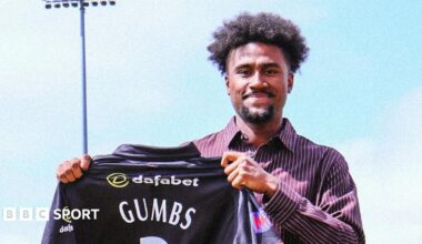 Sheridon Gumbs holds up a Leicestershire shirt after signing for the County Championship side