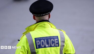 Back of a hi-vis jacket reading 'Greater Manchester Police'.