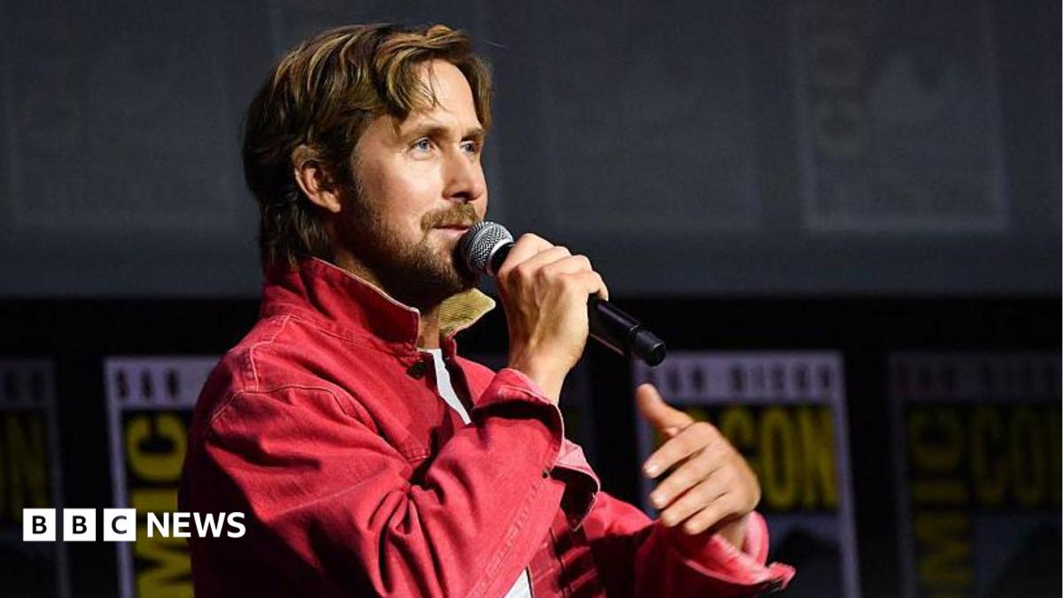 Ryan Gosling speaking into microphone on stage at San Diego Comic-Con