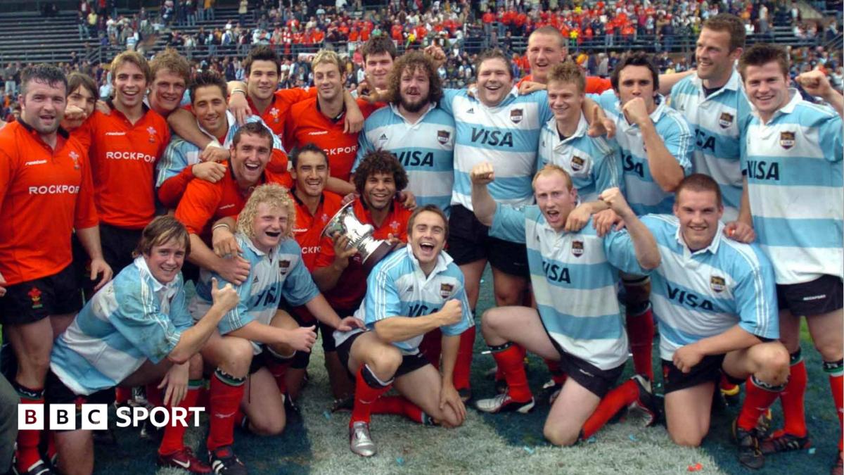 Wales players, some in red Wales shirts and some in blue and white Argentina jerseys, pose together on the pitch on the 2004 tour of Argentina.