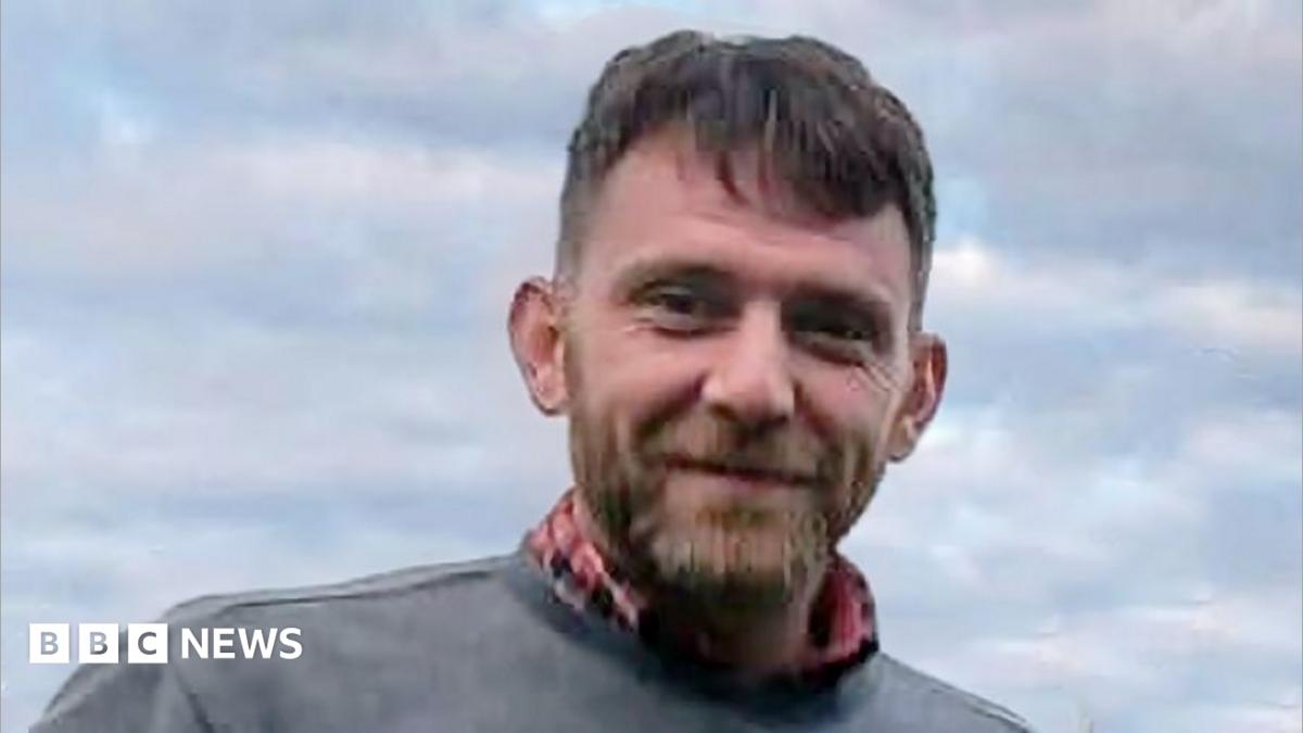 Jim Mair - a man with dark hair and a beard, smiling into the camera
